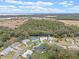 Aerial view of community with homes, trees, and distant water at 27010 Racquet Cir, Leesburg, FL 34748