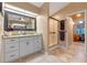 Bathroom with granite countertop, white cabinets and a shower at 27010 Racquet Cir, Leesburg, FL 34748