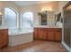 Elegant bathroom with double vanities, a soaking tub, and a walk-in shower at 27504 Stoney Brook Dr, Leesburg, FL 34748
