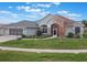 One-story house with light green exterior, two-car garage, and a landscaped yard at 27504 Stoney Brook Dr, Leesburg, FL 34748