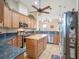 A kitchen featuring wood cabinets, an island, stainless steel appliances, and tiled floors at 27504 Stoney Brook Dr, Leesburg, FL 34748