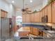 Bright kitchen with stainless steel appliances, wood cabinets, granite counters, and a central island at 27504 Stoney Brook Dr, Leesburg, FL 34748