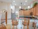 Open kitchen featuring breakfast bar seating, wood cabinets, granite countertops, and tile flooring at 27504 Stoney Brook Dr, Leesburg, FL 34748