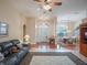 Spacious living room with hardwood floors, a ceiling fan, and a comfortable leather couch at 27504 Stoney Brook Dr, Leesburg, FL 34748