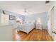 Bright bedroom with light blue walls, hardwood floors, and a queen bed at 3200 Woodridge Dr, The Villages, FL 32162