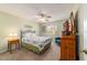 Bedroom with queen bed, ceiling fan and wood dresser at 3200 Woodridge Dr, The Villages, FL 32162