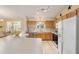 Spacious kitchen featuring wood cabinets, tile backsplash, and an island at 3200 Woodridge Dr, The Villages, FL 32162