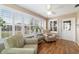 Bright sunroom with hardwood floors, comfortable seating, and large windows at 3200 Woodridge Dr, The Villages, FL 32162