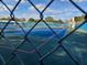 Two tennis courts with chain link fence and blue surface at 32218 Sweet Briar Court, Leesburg, FL 34748