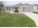 Tan one-story house with 2-car garage and well-maintained lawn at 3243 Mansfield St, The Villages, FL 32162