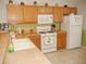 Kitchen with oak cabinets, white appliances, and gas range at 3243 Mansfield St, The Villages, FL 32162