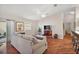 Living room with hardwood floors, couch, ottoman, and view to kitchen at 3347 Empire Ave, The Villages, FL 32163