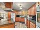 Spacious kitchen featuring wood cabinets, an island, and updated flooring at 34205 Island Dr, Leesburg, FL 34788