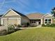 Inviting single-story home boasts a well-maintained lawn, landscaped garden, and a neutral color palette at 3554 Oracle Ct, The Villages, FL 32163