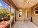 Covered patio with a ceiling fan, a beige-colored door, and screened walls offering views of the outdoors at 3554 Oracle Ct, The Villages, FL 32163