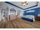 Spacious bedroom featuring wood-look flooring, a ceiling fan, modern decor, and ample closet space at 4442 Shannon Loop, The Villages, FL 32163