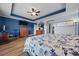 Main bedroom with blue walls, wood-look floors, and king-size bed at 4442 Shannon Loop, The Villages, FL 32163