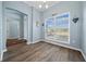 Bright dining room featuring wood-look flooring, a large window, elegant lighting, and a welcoming atmosphere at 4442 Shannon Loop, The Villages, FL 32163