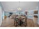 Open concept dining area with hardwood floors and a view of the living room and kitchen at 4442 Shannon Loop, The Villages, FL 32163