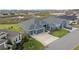 Two-story house with gray exterior, three-car garage, and yard at 4442 Shannon Loop, The Villages, FL 32163
