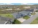 Two-story house with gray exterior, three-car garage, and yard at 4442 Shannon Loop, The Villages, FL 32163