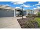 Beautiful home showcasing a manicured lawn, walkway to the entrance, and a spacious three car garage at 4442 Shannon Loop, The Villages, FL 32163