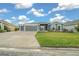 Charming single-story home featuring a well-maintained lawn, a three car garage, and welcoming curb appeal at 4442 Shannon Loop, The Villages, FL 32163