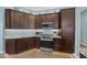 Well-equipped kitchen featuring dark cabinets, stainless steel appliances, granite countertops, and ample storage space at 4442 Shannon Loop, The Villages, FL 32163