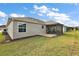 Rear view of home showcasing screened-in patio and lush green lawn at 507 Delfin Rd, The Villages, FL 32163