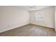 This bedroom features beautiful wood-look floors and a large window at 507 Delfin Rd, The Villages, FL 32163