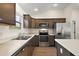 Well-lit kitchen with stainless steel appliances, dark wood cabinets, and light countertops at 507 Delfin Rd, The Villages, FL 32163