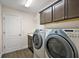 Well-lit laundry room with washer, dryer, built-in cabinets, and neutral decor at 507 Delfin Rd, The Villages, FL 32163