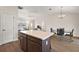 Open-concept living space boasts vaulted ceilings, wood floors, and a combined kitchen and dining area at 507 Delfin Rd, The Villages, FL 32163
