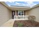Inviting front porch with seating area, decorative door, and manicured landscaping at 507 Delfin Rd, The Villages, FL 32163