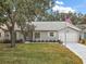 Gray house with a white garage door and landscaped lawn at 5505 Tangelo St, Leesburg, FL 34748