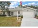 House with gray siding, white garage door, and landscaped lawn at 5505 Tangelo St, Leesburg, FL 34748