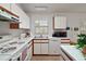 Galley style kitchen with white cabinets and modern appliances at 5505 Tangelo St, Leesburg, FL 34748