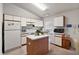 Kitchen island with white cabinets and modern appliances at 5505 Tangelo St, Leesburg, FL 34748