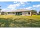 Spacious backyard with grassy area and home view at 5616 Illumination Ln, Leesburg, FL 34748