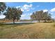 Peaceful backyard oasis with a pond and lush grass at 5616 Illumination Ln, Leesburg, FL 34748