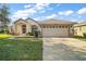 Single-story house with a two-car garage and landscaped lawn at 5616 Illumination Ln, Leesburg, FL 34748