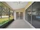 Screened porch with view of the backyard and kitchen at 5616 Illumination Ln, Leesburg, FL 34748
