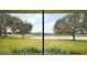 Serene view from the screened porch of lush trees and water at 5616 Illumination Ln, Leesburg, FL 34748