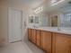 Bathroom with double vanity and wood cabinets at 8633 Se 133Rd Ln, Summerfield, FL 34491