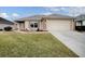 Tan house with a large front yard and a two-car garage at 8633 Se 133Rd Ln, Summerfield, FL 34491
