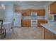 Kitchen with wood cabinets, white appliances, and tile floors at 8633 Se 133Rd Ln, Summerfield, FL 34491