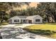 White farmhouse exterior with a welcoming front porch and landscaping at 871 Cr 548, Bushnell, FL 33513
