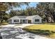 White house with circular driveway, landscaping, and two-car garage at 871 Cr 548, Bushnell, FL 33513