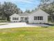 White farmhouse exterior with circular driveway and landscaping at 871 Cr 548, Bushnell, FL 33513