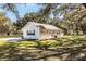 Side view of the house showcasing the garage and landscaping at 871 Cr 548, Bushnell, FL 33513